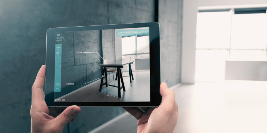 quelqu'un intègre une nouvelle table dans son salon à l'aide de la réalité augmentée sur sa tablette