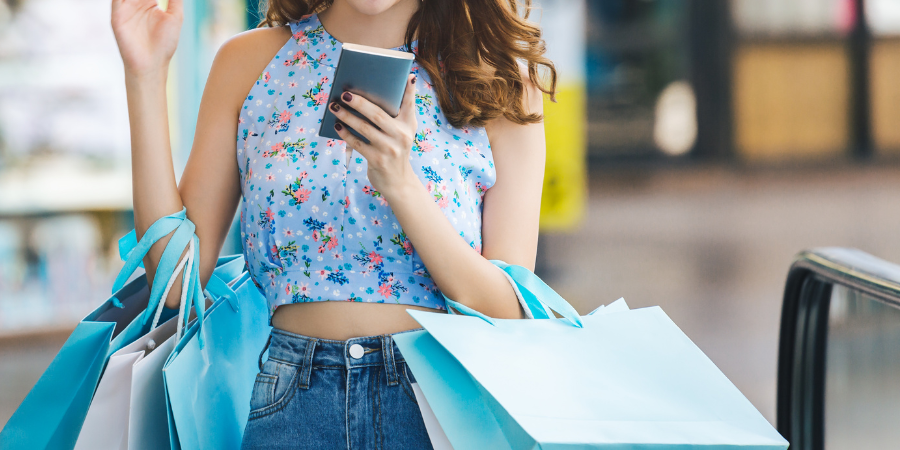 personne avec des sacs de shopping sur son smartphone